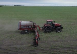 A tractor applies nitrogen to a corn field